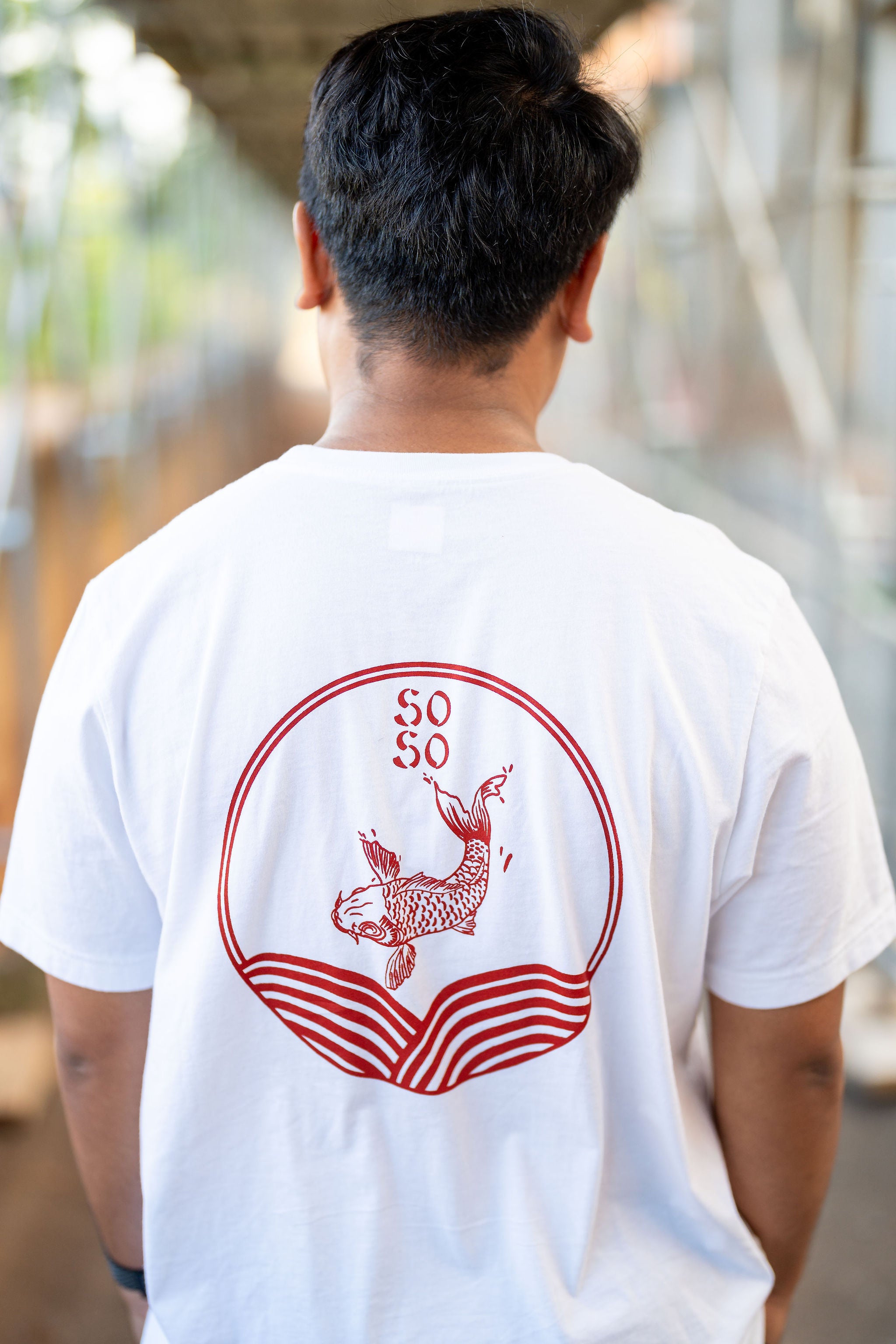 Guy wearing white streetwear shirt with red koi design