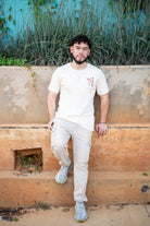 Guy wearing natural color shirt with red spider lily logo