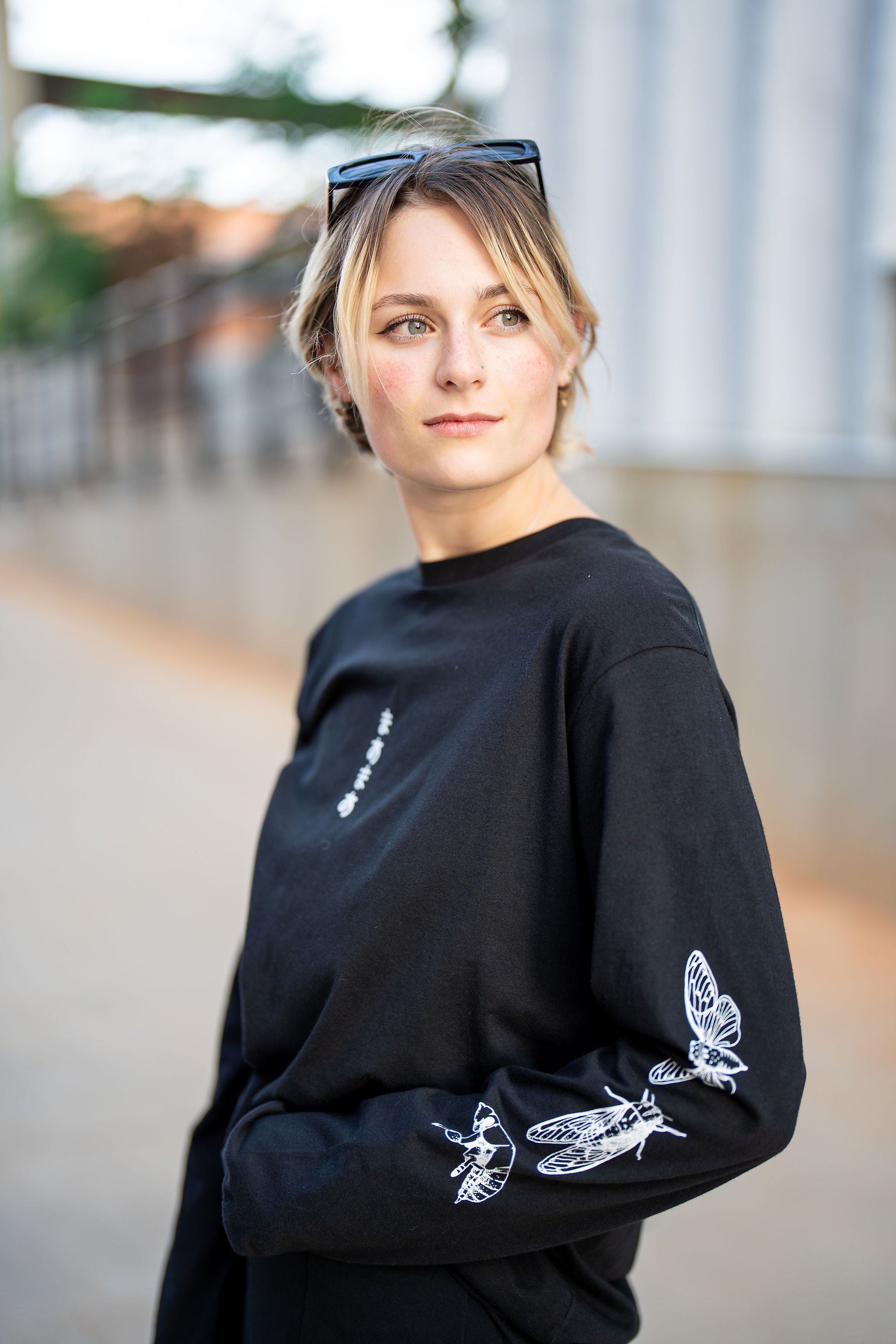 woman wearing long sleeve shirt with white cicada design